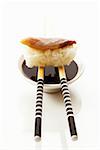Nigiri sushi sur baguettes sur le petit bol de sauce de soja