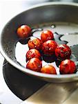 Frying cocktail tomatoes with balsamic vinegar in frying pan