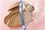 Quatre tranches du mélange de blé et du pain de seigle dans un sac en plastique