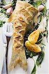 Fried sea bass with herbs, garlic and lemon