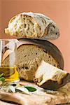 Rustic bread, two loaves with pieces cut off, olive oil, salt