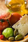 Tomates, olives vertes et Parmesan sur plaque, huile d'olive