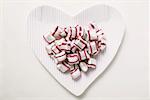 Cherry mint sweets on heart- shaped paper plate