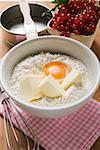 Flour, butter, egg in bowl, redcurrants and baking tin