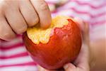 Child holding nectarine with bites taken