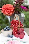 Petits fruits frais et fleurs sur la table rustique