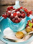 Redcurrants in glass jug, sugar, gooseberries