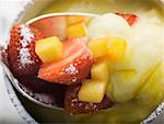 Mango cream with strawberries and icing sugar