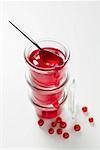 Three jars of redcurrant jelly, one opened, with spoon