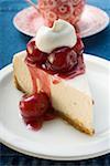 Piece of cheesecake with cherries and cream