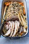 Rolled pork roast with herbs, carrots, parsley roots