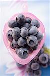 Fresh blueberries in pink glass jug (overhead view)