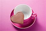 Chocolate heart on pink coffee cup