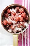 Sugared raspberries in a pan (overhead view)