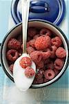 Framboises dans une casserole et la cuillère de sucre (vue aérienne)