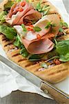 Parma ham, herbs and chili rings on pizza bread