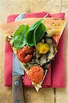 Stück Pizza mit Tomaten, Auberginen und Basilikum