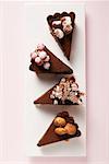 Vier Stück Schokolade Torte mit verschiedenen Dekorationen