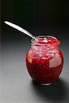 Raspberry jam in jar with spoon