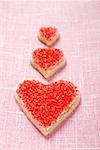 Three heart-shaped biscuits with red sugar
