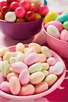 Different kinds of sweets and bubble gum balls in bowls