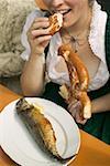 Femme mangeant bretzel & Steckerlfisch (brochette de poisson), fête de la bière