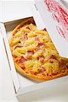 Hawaiian pizza with ham and pineapple in pizza box