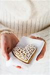 Hands holding gingerbread heart on napkin (Christmassy)