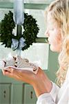 Blond girl holding assorted gingerbread biscuits on napkin