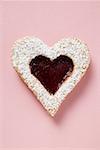 Heart-shaped biscuit with raspberry jam and icing sugar