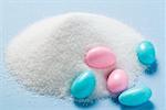 Coloured sugared almonds with a heap of sugar