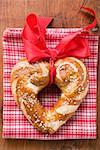 Heart-shaped lye roll with red bow on tea towel