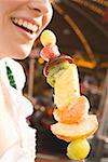 Woman holding skewered candied fruit (Oktoberfest, Munich)