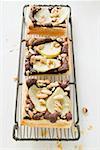 Three pieces of pear & chocolate tart with almonds on rack