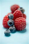 Blueberries and raspberries on blue background