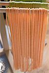 Home-made red pasta, hanging up to dry