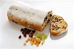 Stollen with icing sugar, a slice cut, and ingredients