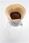 Ground coffee in filter on glass coffee pot