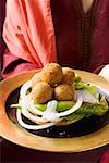 Femme au service de falafel (boulettes de pois chiche) avec des légumes