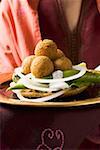 Woman serving falafel (chick-pea balls) with vegetables