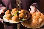 Woman serving falafel (chick-pea balls) with flatbread