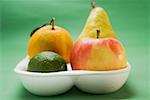 Orange, pear, lime and apple in polystyrene tray