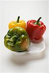 Three peppers (yellow, red, green) in polystyrene tray