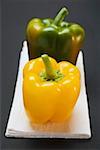 Two peppers (yellow, green) on white linen cloth