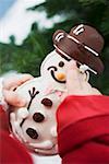 Child holding snowman biscuit