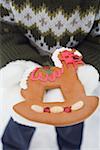 Child holding gingerbread rocking horse