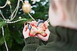 Child holding gingerbread horse (tree ornament)