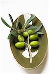 Olive sprig with green olives in bowl