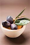 Olive sprig with black olives in terracotta bowl