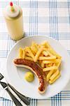 Bratwurst mit Pommes und Senf auf Teller im restaurant